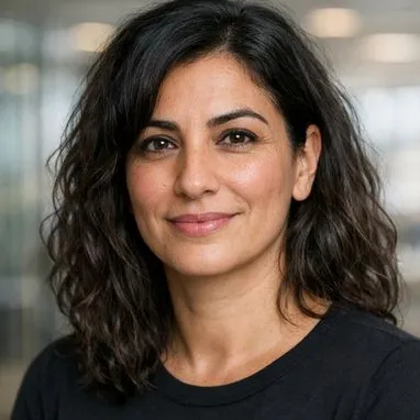 Woman in her early 40s, wavy dark hair, warm olive skin, calm expression